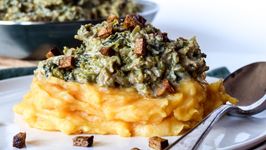 Rahmwirsing auf Kartoffelpüree auf weissem Porzellanteller mit Löffel