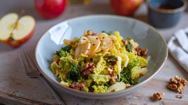 Wirsingsalat mit Apfel im Porzellanschälchen von Zutaten umgeben