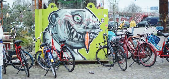 Streetart-Malerei "Glatzkopf mit spitzen Zähnen", davor Fahrräder