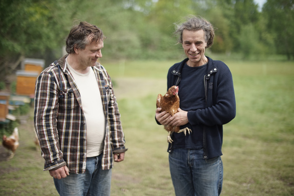 Jens und Felix mit Huhn auf der grünen Wiese