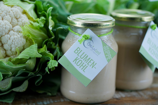 KI generiert: Glas mit Blumenkohl-Suppe und Blumenkohl. Text: "Blumenkohl", "Weißblech ist unendlich oft recyclebar".