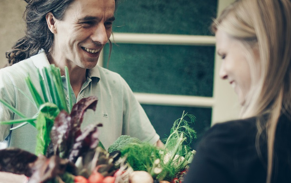 KI generiert: Zwei Personen lächeln, während sie frisches Gemüse betrachten.
