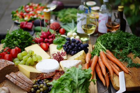 Ein Tisch voller frischer Lebensmittel: Gemüse, Obst, Käse und Brot.