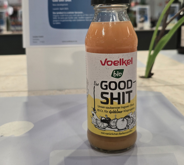 KI generiert: Ingwer-Shot von Voelkel mit dem Namen "the GOOD SHIT". Text: "Unser sauberster Ingwer-Shot."