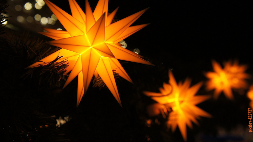 Herrnhuter Sterne in gelb leuchtend bei Nacht