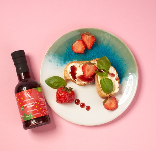 Fruchtige Balsamico Creme mit Erdbeere neben einem angerichteten Teller