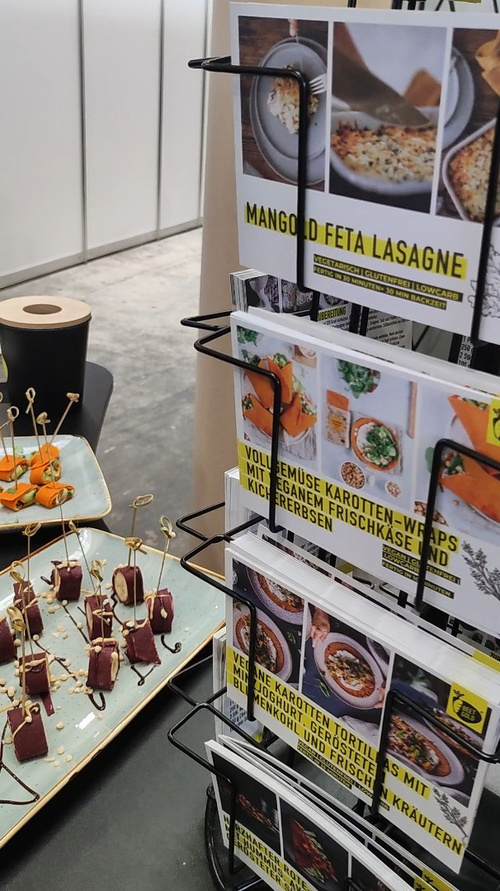 Rezeptkarten von Beetgold, die Gemüsewraps herstellen, im Hintergrund Probierhäppchen