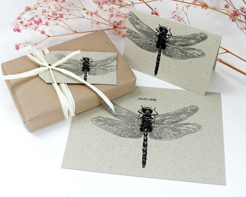 KI generiert: Geschenk mit Karte und Etikett, Libellenmotiv, Text: "ALLES LIEBE".