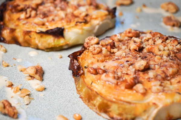 KI generiert: Zwei gebackene Gemüsescheiben mit gehackten Nüssen garniert auf einem Teller.