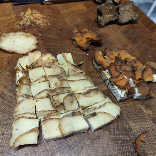 KI generiert: Geschnittene Pilze auf einem Holzbrett, mit Würfeln und Scheiben.
