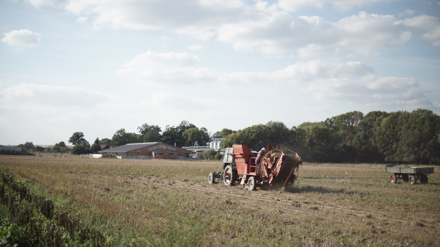 Trecker auf Feld mit wolkigem Himmel