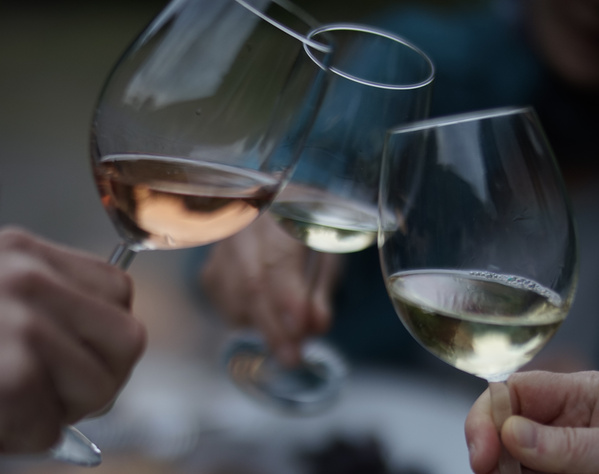 KI generiert: Drei Menschen stoßen mit Weingläsern an.