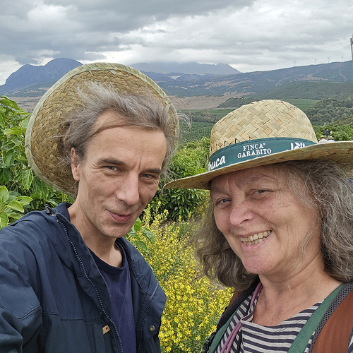 Das Bild zeigt eine Gruppe von fünf Personen, die in einem Lieferwagen stehen und Pflanzen in schwarzen Kisten halten. Sie lächeln in die Kamera und präsentieren die Setzlinge.