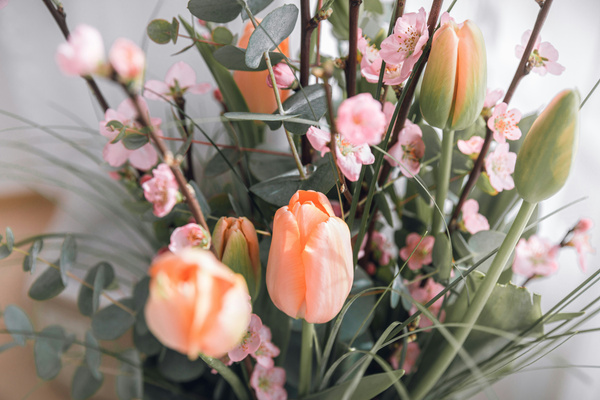 KI generiert: Ein Blumenstrauß mit rosa Tulpen und kleinen Blüten vor unscharfem Hintergrund.