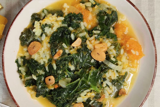 KI generiert: Ein Teller mit Grünkohl und Reis in Brühe, garniert mit Knoblauchscheiben.