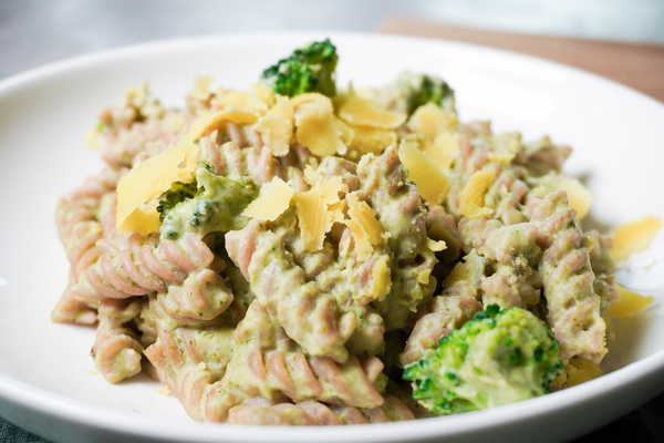 KI generiert: Ein Teller mit Nudeln, Brokkoli und Käsestreifen in einer cremigen Sauce.