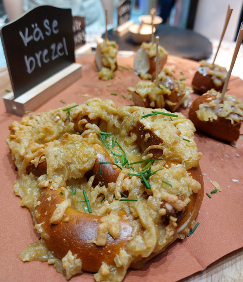 KI generiert: Käsebrezel auf einem Tablett, bestreut mit Schnittlauch.