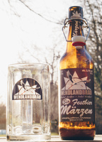 Eine Bierflasche und ein Glas mit "WENDLANDBRÄU Bio Festbier Märzen" im Freien.