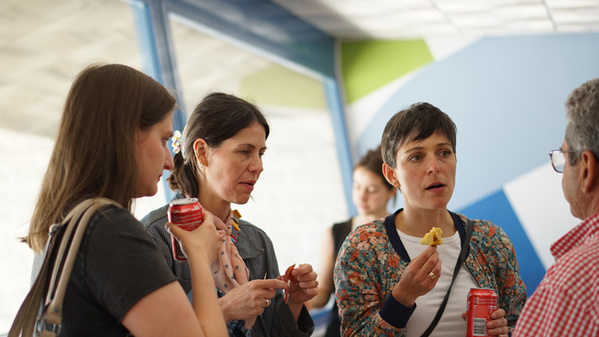 KI generiert: Vier Personen unterhalten sich und halten Getränke.