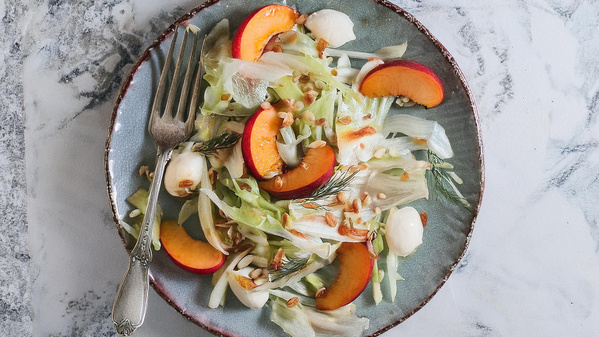 KI generiert: Ein Teller mit Salat, Nektarinen und Mozzarella, garniert mit Dill und einer Gabel an der Seite.