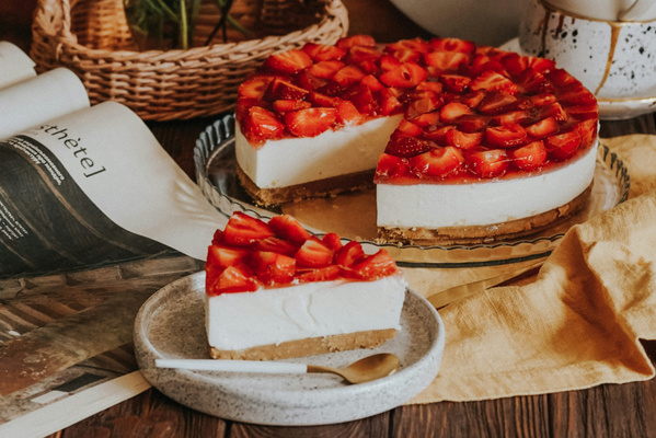 KI generiert: Ein Erdbeerkuchen mit Sahneschicht, ein Stück fehlt. Textausschnitt: „thète]“.