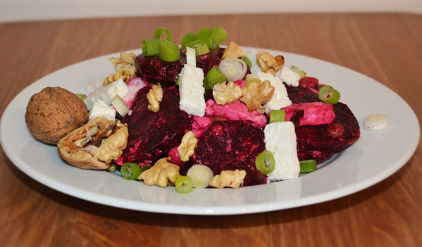 KI generiert: Rote-Bete-Salat mit Feta, Walnüssen und Frühlingszwiebeln auf einem Teller.