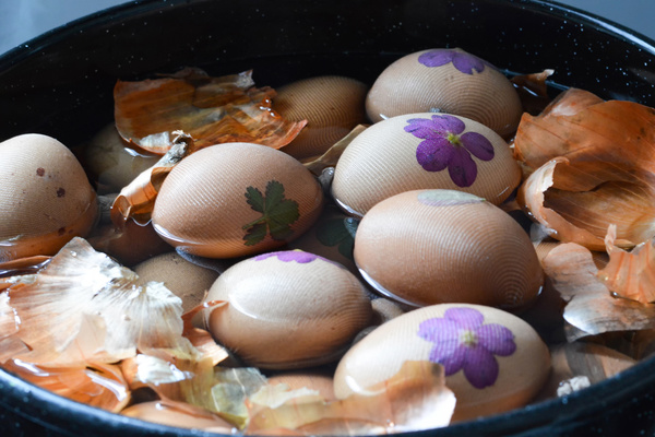 Eier werden im Topf mit Blättern und Blüten verziert