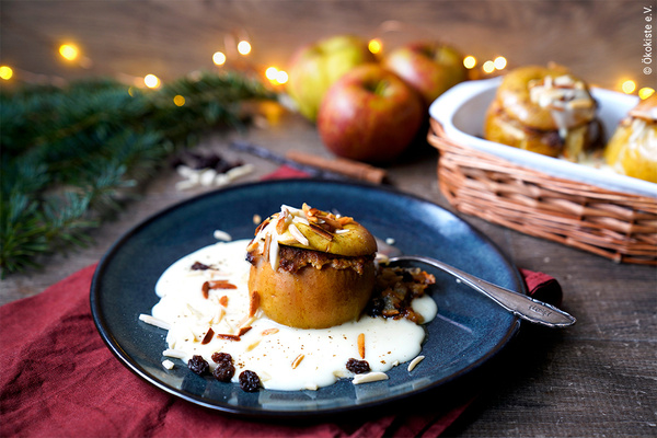 gefüllter Bratapfel mit Vanillesauce auf Keramikteller