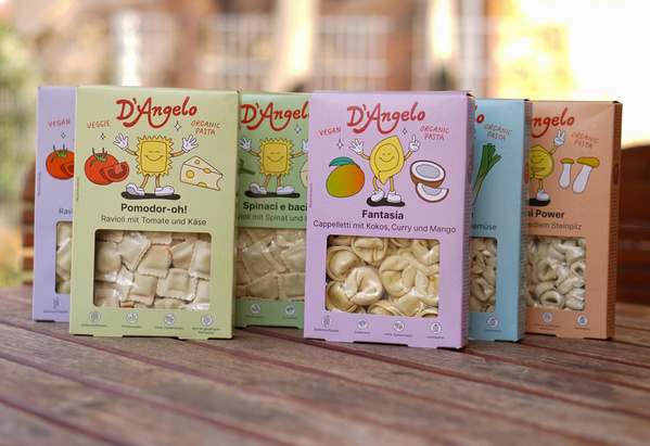 KI generiert: Verschiedene Verpackungen von veganer Pasta der Marke D'Angelo auf einem Tisch.