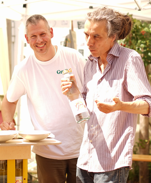 KI generiert: Zwei Männer im Gespräch, einer hält eine Wasserflasche.