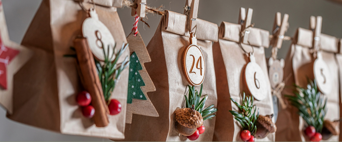 KI generiert: Ein selbstgemachter Adventskalender aus Papierbeuteln, dekoriert mit Zahlen, Zweigen und Zimtstangen.