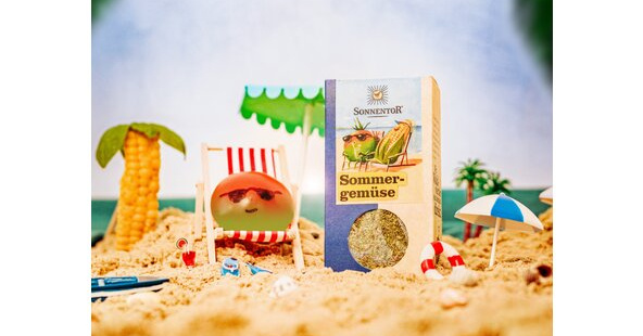 KI generiert: Eine Sommerlandschaft mit Sonnentor Sommergemüse-Packung im Sand.