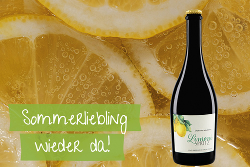  Eine Flasche Limoncello vor Zitronenscheiben. Text: Sommerliebling wieder da!