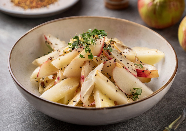 KI generiert: Ein Salat mit Apfelstücken und Kräutern in einer Schale.
