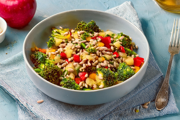 KI generiert: Ein frischer Brokkolisalat mit Paprika und Sonnenblumenkernen in einer Schüssel.