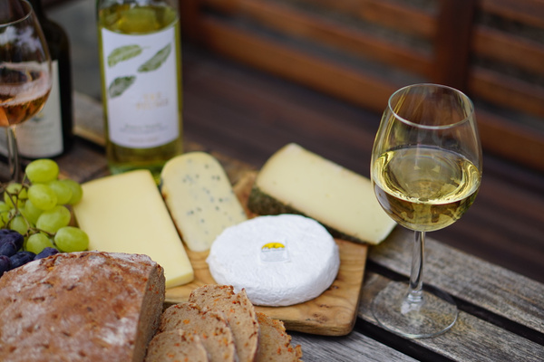 Weissweinglas mit Käseauswahl und Brot