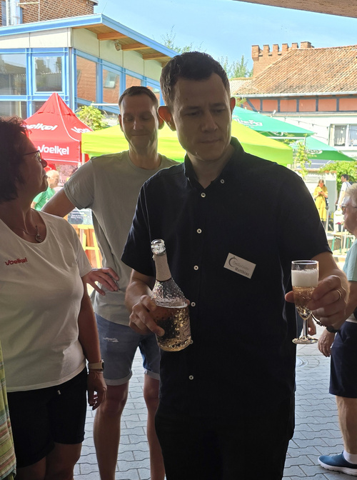 KI generiert: Ein Mann schenkt ein Getränk in ein Sektglas ein.