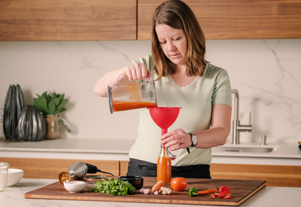 Köchin Parvin Razavi präsentiert gekochtes Gericht auf Teller angerichtet