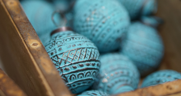 KI generiert: Ein Haufen türkisfarbener, gemusterter Kugelornamente in einer Holzbox.