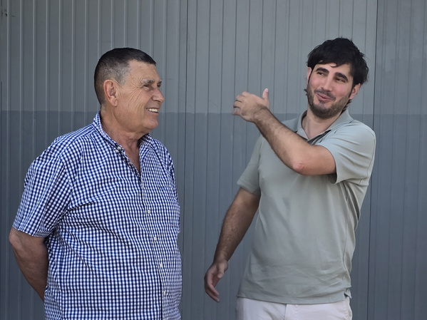 KI generiert: Zwei Männer unterhalten sich freundlich vor einer grauen Wand.