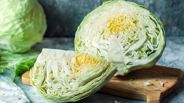 KI generiert: Zwei geschnittene Weißkohl-Köpfe auf einem Holzbrett.