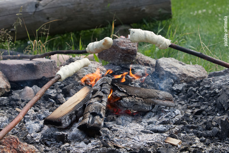 Stockbrotgrillen über dem offenen Lagerfeuer