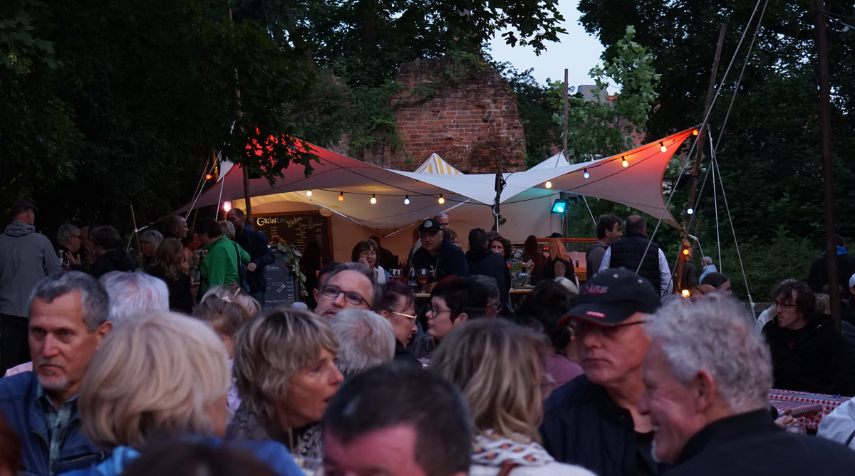 Blick auf den Grünlandstand auf dem Weinfest, Menschenköpfe im Vordergrund
