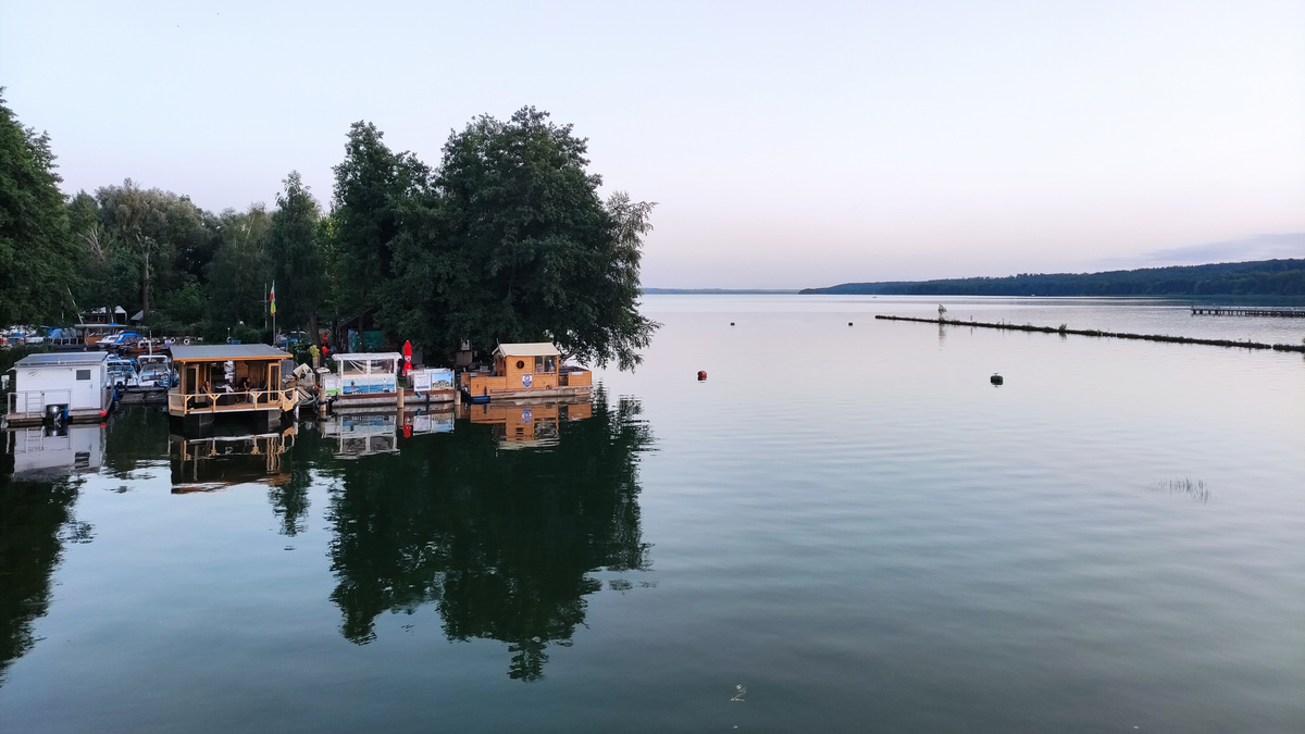 Hausboote am Uferrand eines Sees in Abenddämmerung