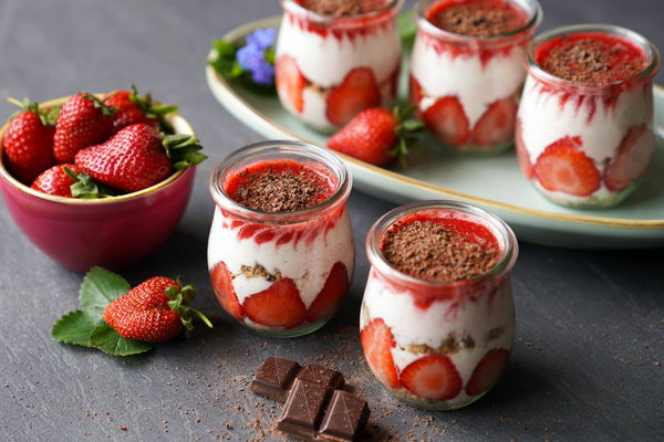 KI generiert: Desserts im Glas mit Erdbeeren und Schokolade; Schüssel voller frischer Erdbeeren.