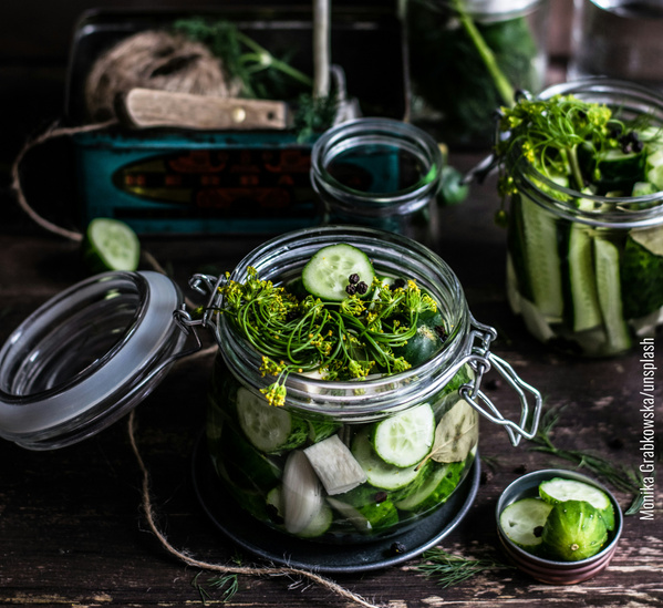 KI generiert: Ein Glas mit frischen Gurken und Dill auf einem Tisch, bereit für die Fermentation.