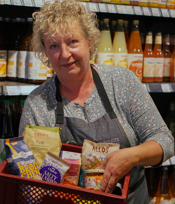 KI generiert: Eine Person im Supermarkt hält einen Korb mit Bio-Lebensmitteln in der Hand.