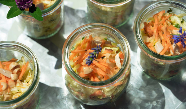 KI generiert: Salat in mehreren Gläsern, dekoriert mit Kräutern und essbaren Blüten.