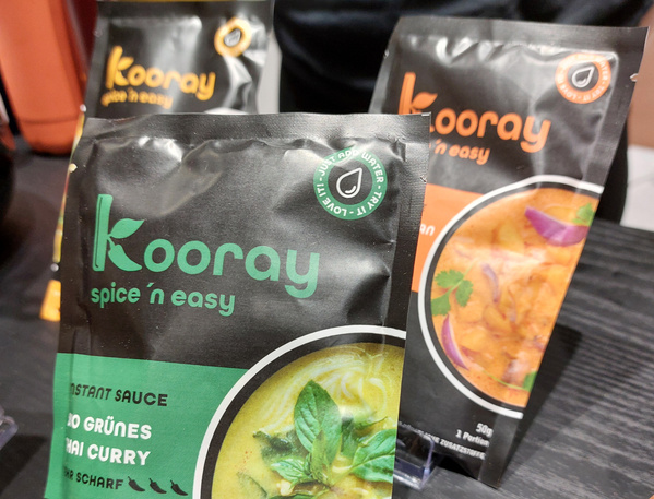 KI generiert: Verpackungen von "Kooray" Gewürzmischungen auf einem Tisch.