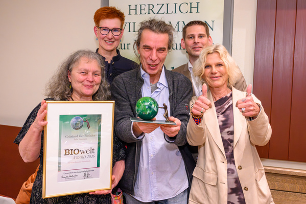 KI generiert: Eine Gruppe von Personen hält eine Auszeichnung, "BIOwelt AWARD 2026".